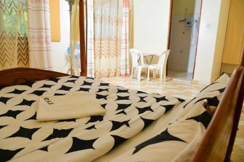 a bed with a black and white comforter in a room at Country Side Homes Kasese in Kasese
