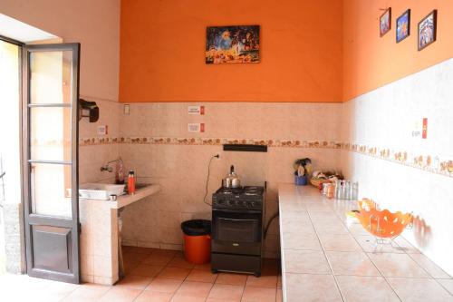 una cucina con piano cottura e parete arancione di Colors House a Sucre
