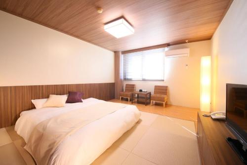 a bedroom with a large bed and a television at Nasu Ichiya Hotel in Nasu