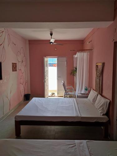 a bedroom with a large bed in a pink wall at Vanam Pool Stay in Pondicherry
