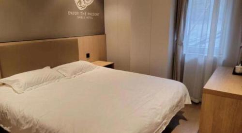 a bedroom with a white bed and a window at Shell Hotel Beijing Shunyi District Shunyi Metro Station in Beijing