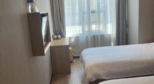 a hotel room with two beds and a television at Shell Hotel Beijing Shunyi District Shunyi Metro Station in Beijing