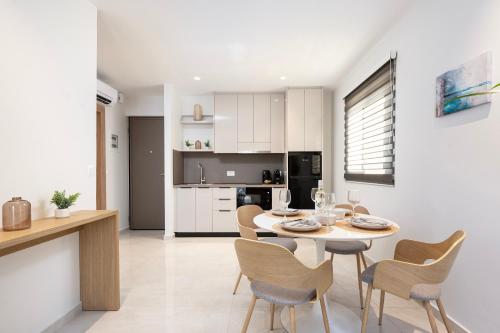 a kitchen and dining room with a table and chairs at Unicos City Suites in Kos Town