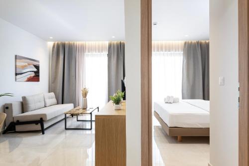 a bedroom with a bed and a living room at Unicos City Suites in Kos Town