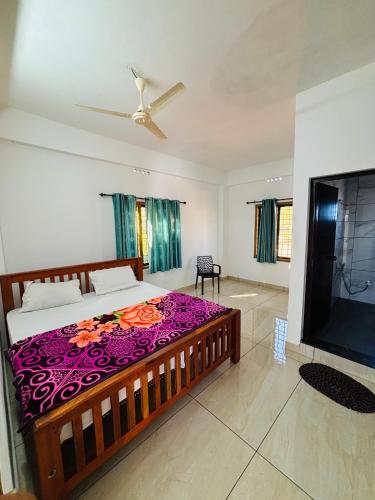 a bedroom with a large bed and a flat screen tv at Aromal holidays in Vagamon