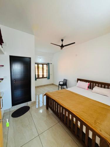 a bedroom with a large bed and a black door at Aromal holidays in Vagamon