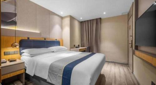 a hotel room with a large bed and a television at City Comfort Inn Hotel Wuhan Optics Valley Square Metro Station Zhongnan Minzu University in Wuhan