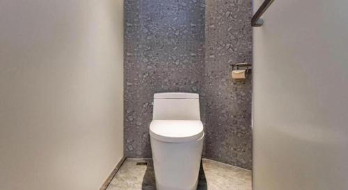 a bathroom with a white toilet in a stall at Borrman Hotel Chongqing Bishan Central Street in Chongqing