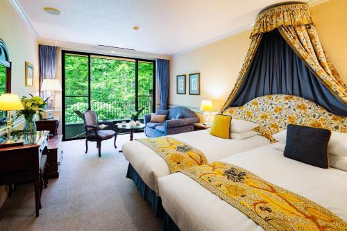 a hotel room with two beds and a desk at Hotel La Neige in Hakuba