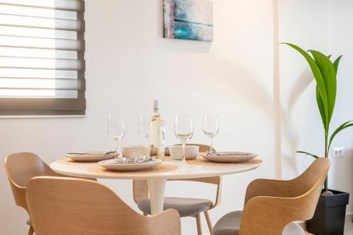 a dining room table with wine glasses and chairs at Unicos City Suites in Kos Town