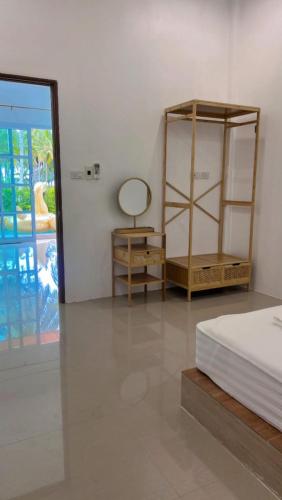 a bedroom with a bed and a mirror and a table at Hadkaew Thepha Pool Villa by Jehsana in Ban Krong I Tam