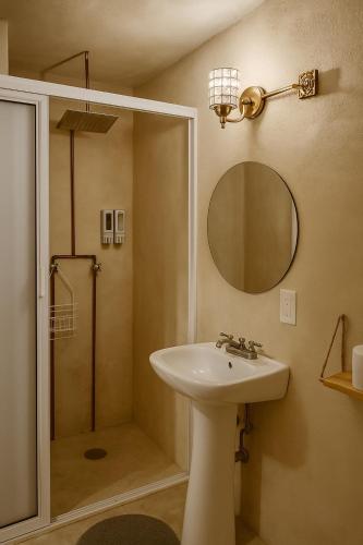 a bathroom with a sink and a shower with a mirror at Burgos Studio in Cancún