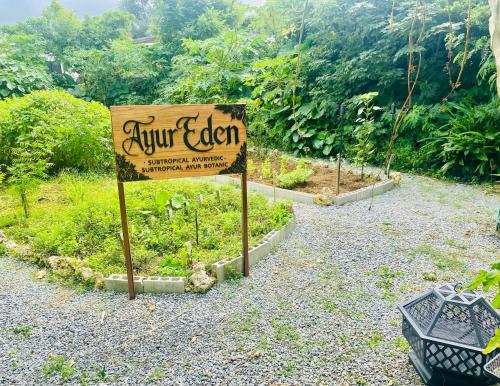 a sign in the middle of a garden at Ayurwellness Resort Okinawa in Motobu