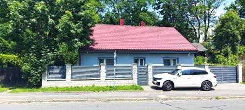 a white car parked in front of a blue house at Villa Tomima in Ostrava