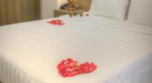 a pile of red flowers on a white bed at Bacninh Charming Hotel in Bắc Ninh