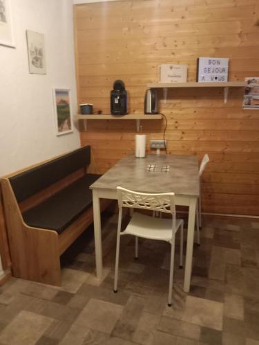 a table and chairs with a bench in a room at Gîte au pied des volcans d'Auvergne Aydat in Aydat