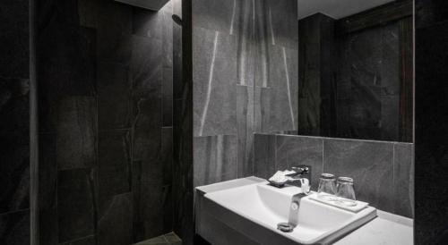 a bathroom with a sink and a mirror at XOTEL in Khon Kaen