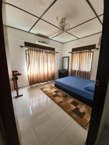 a bedroom with a blue bed and a television at D Tasek Homestay Lenggong 