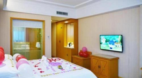 a bedroom with a bed and a flat screen tv at Vienna Hotel Shenzhen Bao'an Airport Taoyuanju Pingluanshan Metro Station in Shenzhen