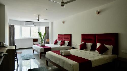 een slaapkamer met 2 bedden met rode hoofdeinden bij Heritage Suites in Mysore
