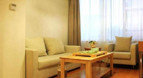 a living room with a couch and a coffee table at GreenTree Inn Fuzhou Gulou District West Xierhuan Road Zuohai Park in Fuzhou