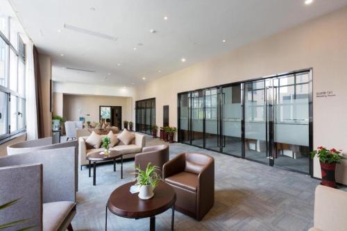 an office lobby with couches and chairs and tables at GRACE Select Hotel (Kunshan Huaqiao International Convention Center) in Suzhou