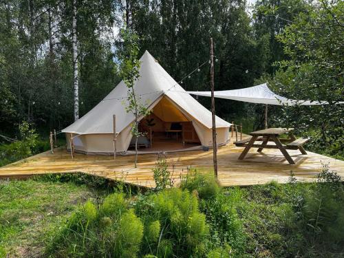 a tent with a picnic table on a wooden deck at Slow Life Sweden - Family Glamping Tent Poppel 