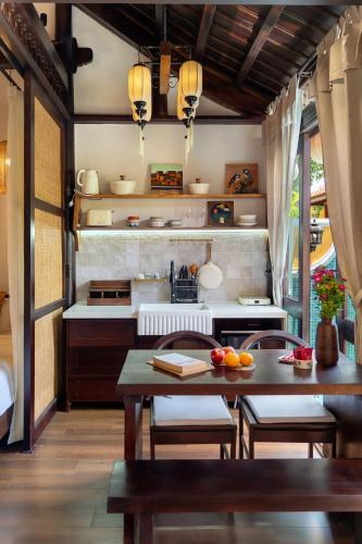 a kitchen with a table and chairs and a counter at Hội An Wooden Retreat In Town in Hoi An
