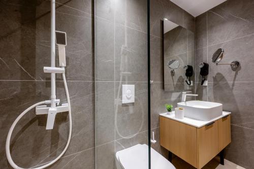 a bathroom with a shower and a toilet and a sink at Unicos City Suites in Kos Town