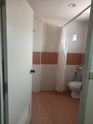 a bathroom with a toilet and a shower curtain at SS welcome jomtien in Jomtien Beach