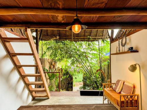 a living room with a staircase and a couch at Zen Treehouse in General Luna