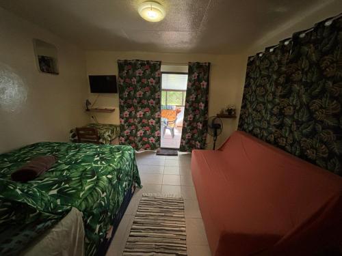 a bedroom with a bed and a door to a patio at Iaoraboraborahouse TEREIA in Bora Bora