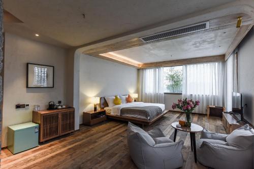 重慶市にあるChongqing Staying Cultural Holiday Homestayのベッドルーム1室(ベッド1台、椅子2脚付)