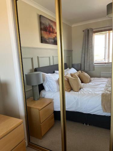 a mirror in a bedroom with a bed at Covesea Horizon in Elgin