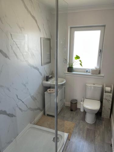 a bathroom with a shower and a toilet and a sink at Covesea Horizon in Elgin