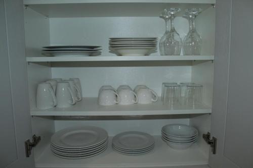 a cupboard filled with plates and vases and dishes at Covesea Horizon in Elgin