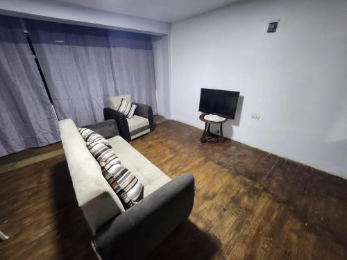 ein Wohnzimmer mit Sofa und Fernseher in der Unterkunft Departamento esmeralda in Chota