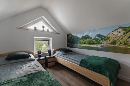 two beds in a bedroom with a painting on the wall at Domek Pod Czereśnią in Szczawnica