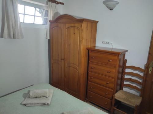 una camera da letto con armadio in legno e cassettiera di Verde casa eden a Tías