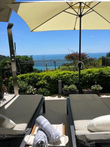 a patio with an umbrella and a table and chairs at IL MARE BLU in Lerici