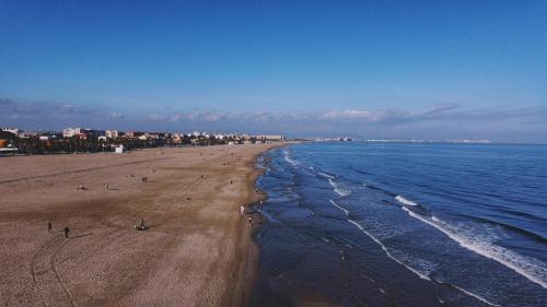 a beach with people on the sand and the water at HOSTAL LETTO DAL MARE in Valencia