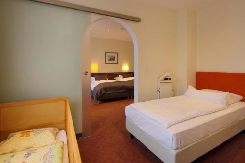 a hotel room with two beds and a mirror at Trip Inn Hotel Esplanade, Düsseldorf in Düsseldorf