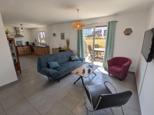 un salon avec un canapé bleu et une table dans l'établissement La Belle Paimpolaise, à Paimpol