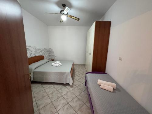 a bedroom with a bed and a ceiling fan at CASA VACANZA BORGOROSSO A 70mt DAL MARE in Casa Borgorosso