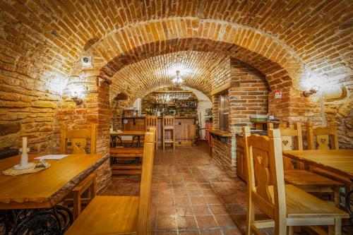 a restaurant with a brick wall and wooden tables at An der Holztreppe in Sighişoara