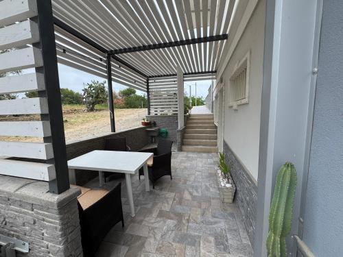 a patio with a white table and chairs and a staircase at CASA VACANZA BORGOROSSO A 70mt DAL MARE in Casa Borgorosso