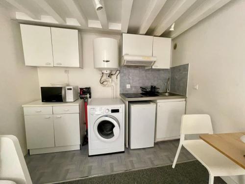 une cuisine avec des armoires blanches et une laveuse et une sécheuse dans l'établissement Studio au coeur du centre historique, à Bordeaux
