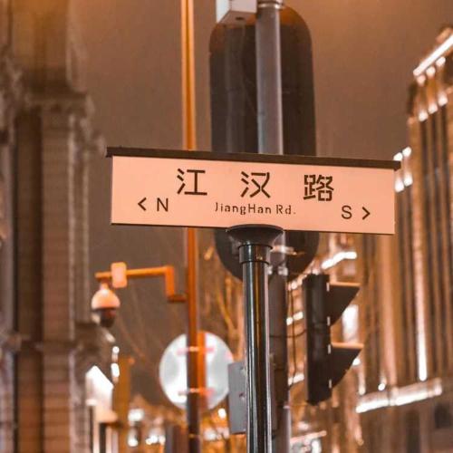 a street sign on a pole in a city at Home Inn Huayi Selected Yellow Crane Tower Tang Hualin Branch in Wuhan