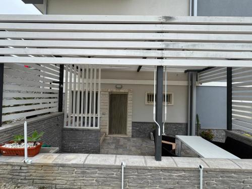 a patio with a white pergola in front of a house at CASA VACANZA BORGOROSSO A 70mt DAL MARE in Casa Borgorosso