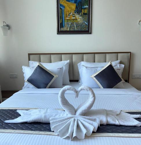 two swans made out of towels on a bed at Montecarlo Hotel in Mahabalipuram